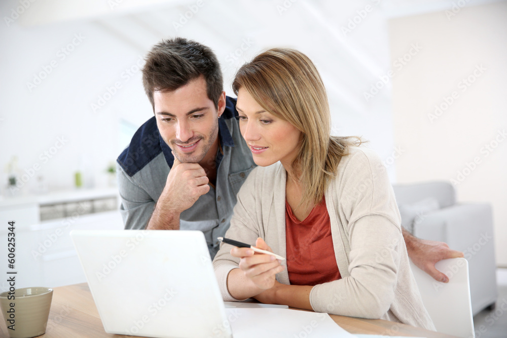Couple at home working on laptop computer Couple at home working on laptop computer