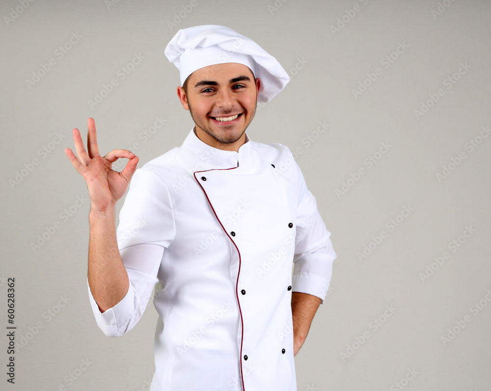 Professional chef in white uniform and hat, on gray background Professional chef in white uniform and hat, on gray background