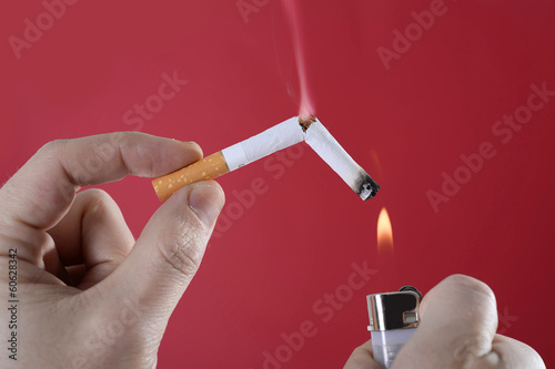 Male hand holding broken cigarette smoking and lighter