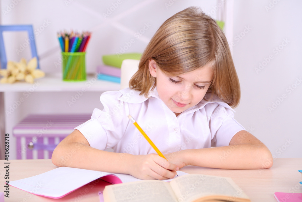 Little girl sitting at desk in room Little girl sitting at desk in room