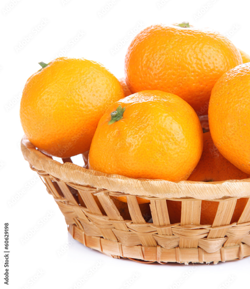 Ripe sweet tangerines in wicker basket, isolated on white Ripe sweet tangerines in wicker basket, isolated on white
