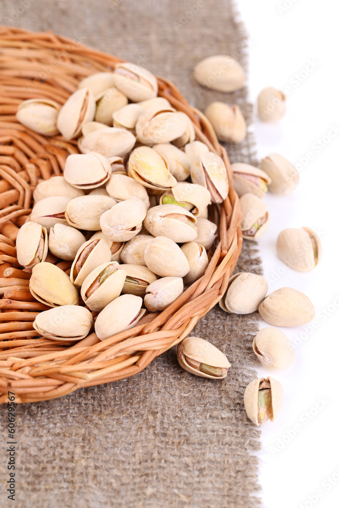 Pistachio nuts on wicker stand with sackcloth close up Pistachio nuts on wicker stand with sackcloth close up