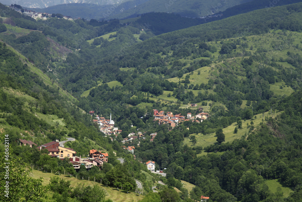 Village with red roofed houses in the wooded mountains in Kosovo