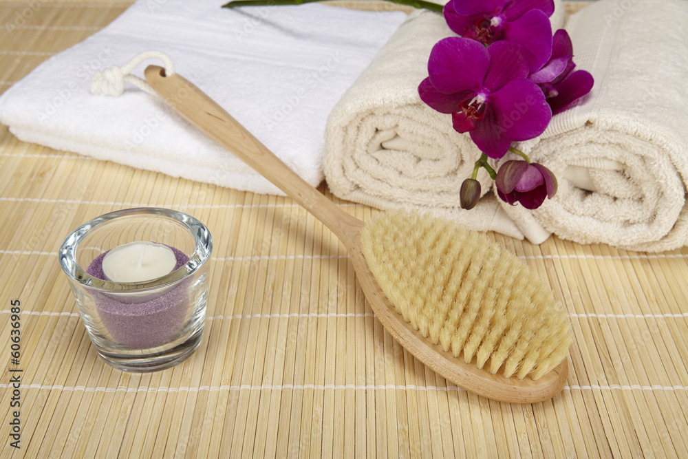 Badebürste, Handtücher und Orchidee auf Bambusmatte Badebürste, Handtücher und Orchidee auf Bambusmatte
