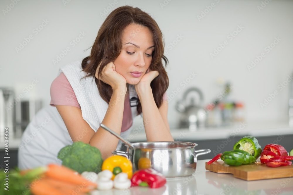 Serious woman preparing food in kitchen