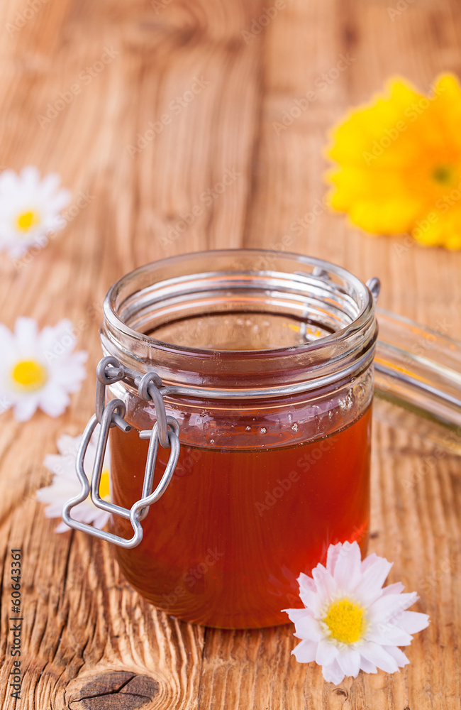 Honey in jar with honeycomb and wooden drizzler Honey in jar with honeycomb and wooden drizzler