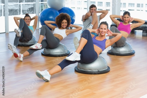 Portrait of cheerful fitness class doing pilates exercise