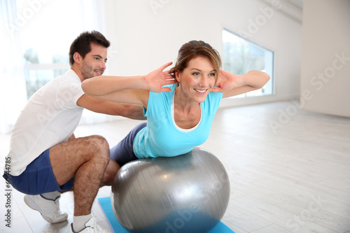 Woman doing pilates exercises with coach photo