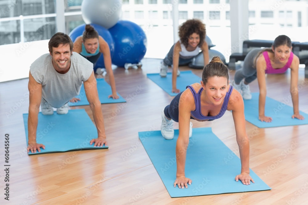 People doing push ups in fitness studio People doing push ups in fitness studio