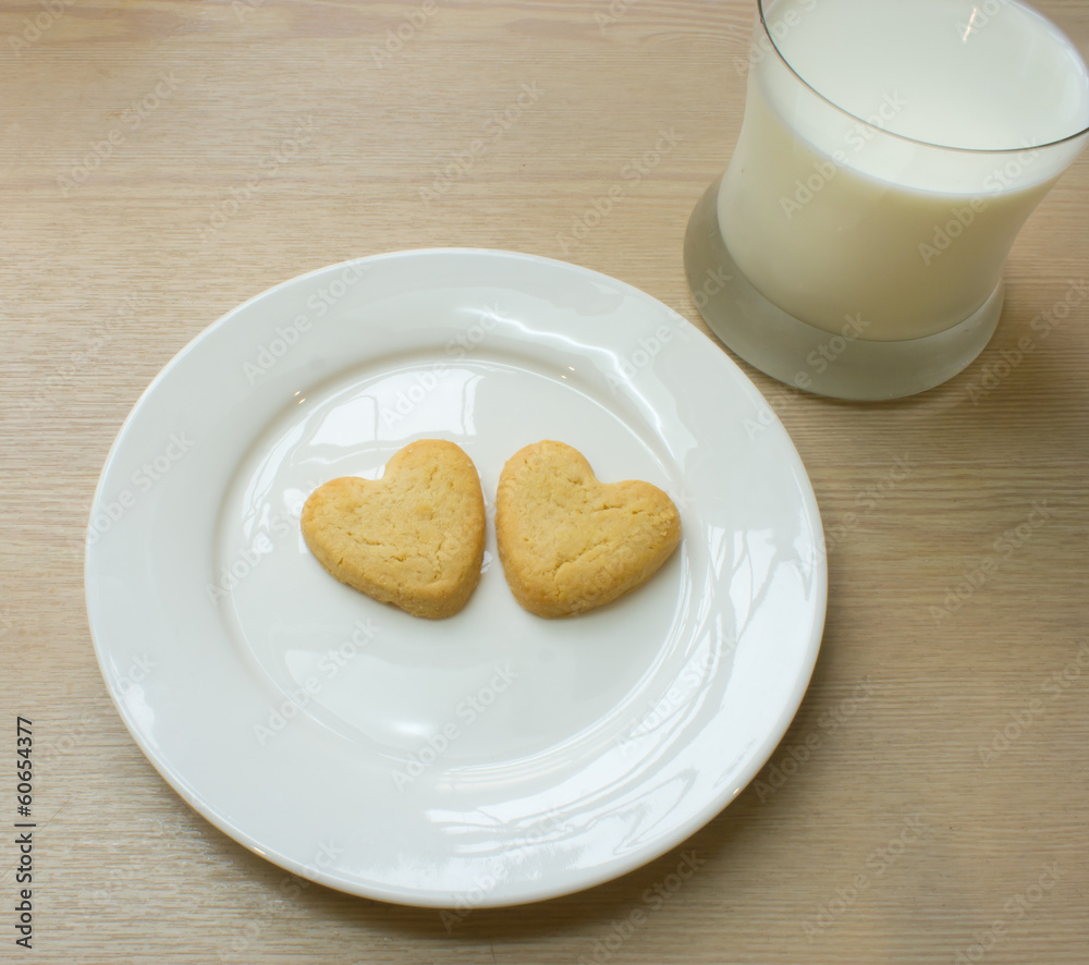 Heart cookies on white plate and glass of milk. Heart cookies on white plate and glass of milk.