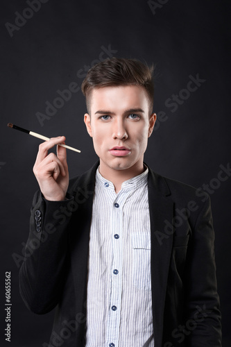 Stylish young handsome man in a suit with a brush.