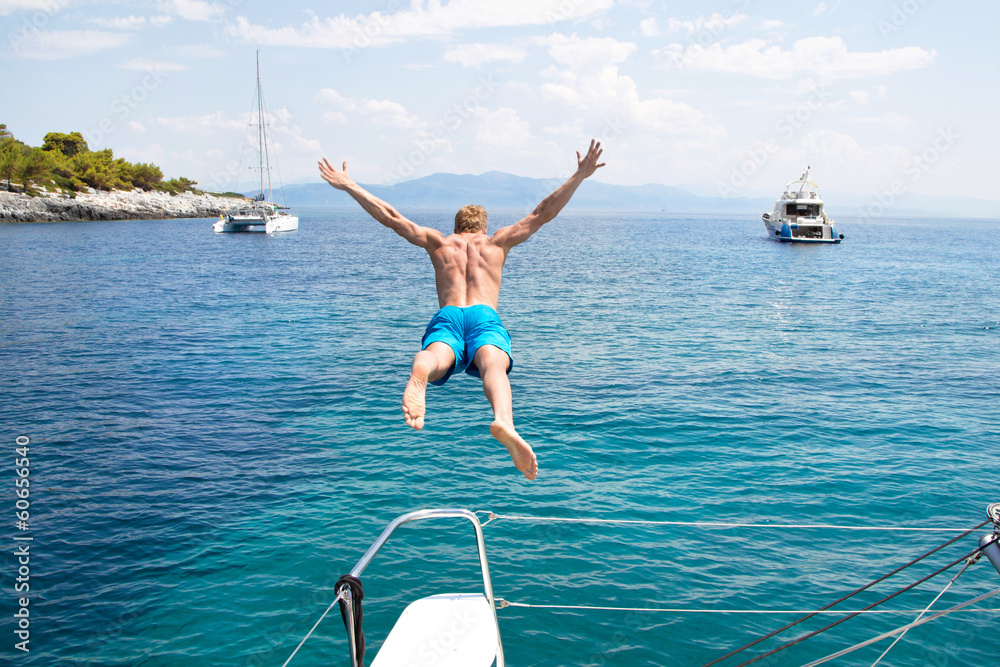 Freiheit, Abenteuer - Mann springt vom Boot aus ins Meer - obrazy, fototapety, plakaty 