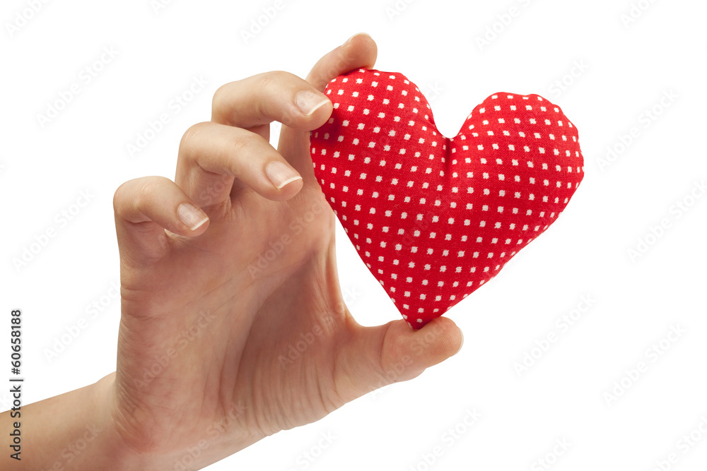 Woman hand holds home made stuffed textile red heart Woman hand holds home made stuffed textile red heart
