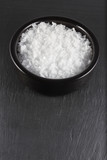 Sea salt flakes, in bowl . Space at bottom of image.