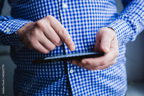 The man uses a tablet PC. Modern gadget in hand.