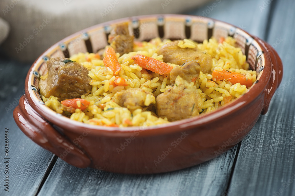 Ceramic plate with uzbek national pilaf, horizontal shot