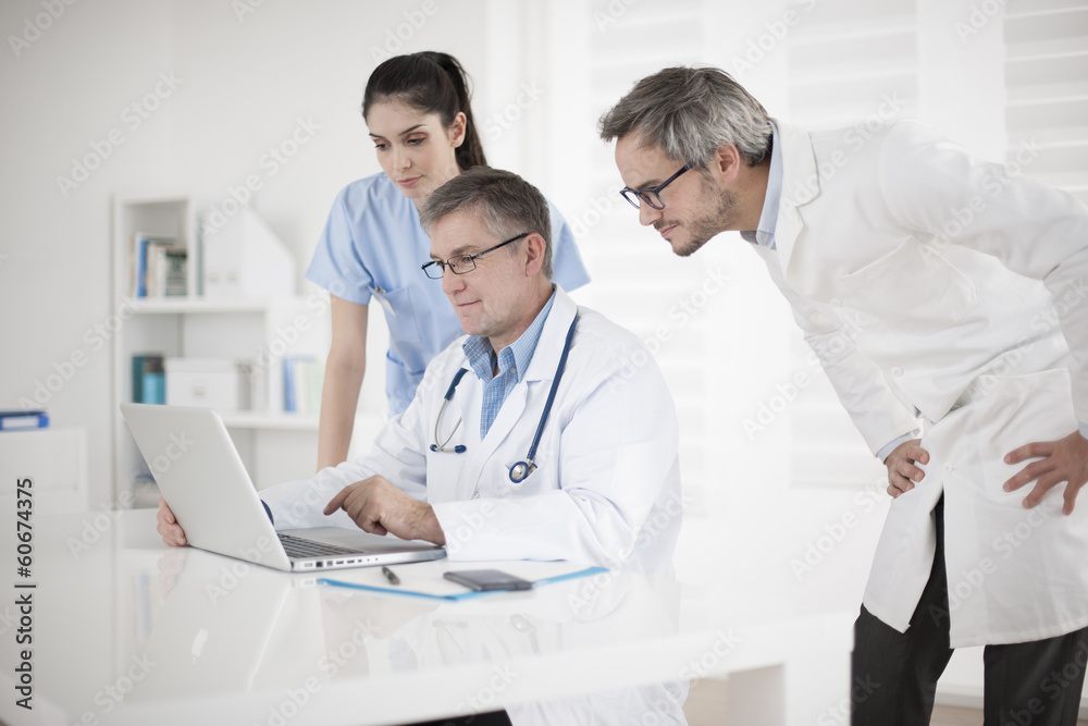 medical team discussing around a computer medical team discussing around a computer