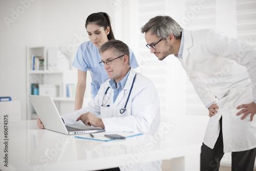 medical team discussing around a computer
