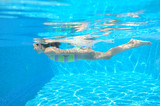 Happy active child swims underwater in pool and have fun