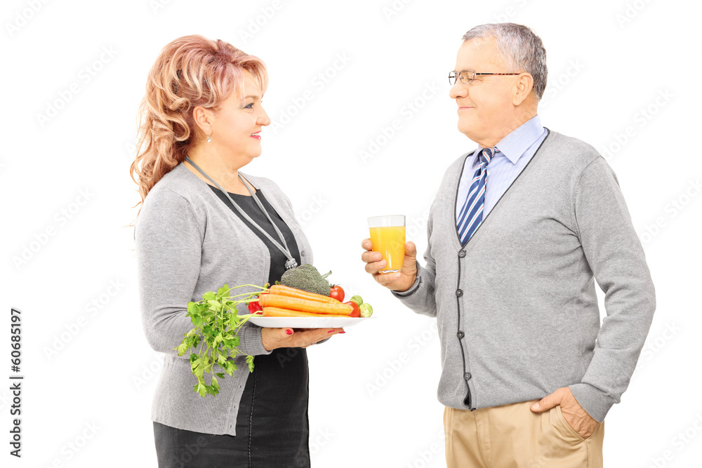 Mature couple holding plate full of vegetables Mature couple holding plate full of vegetables