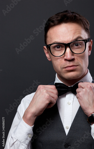 Man with beard correcting his bowtie © Sergey