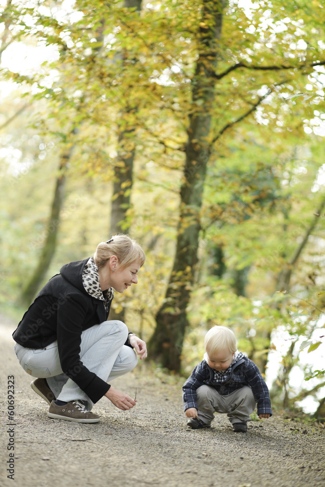 little boy with mother on outdoor walk in autumn park