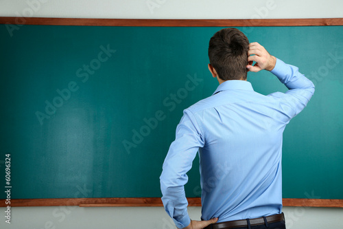 Young teacher near chalkboa...
