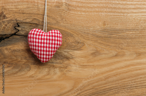 Love heart hanging on wooden texture background