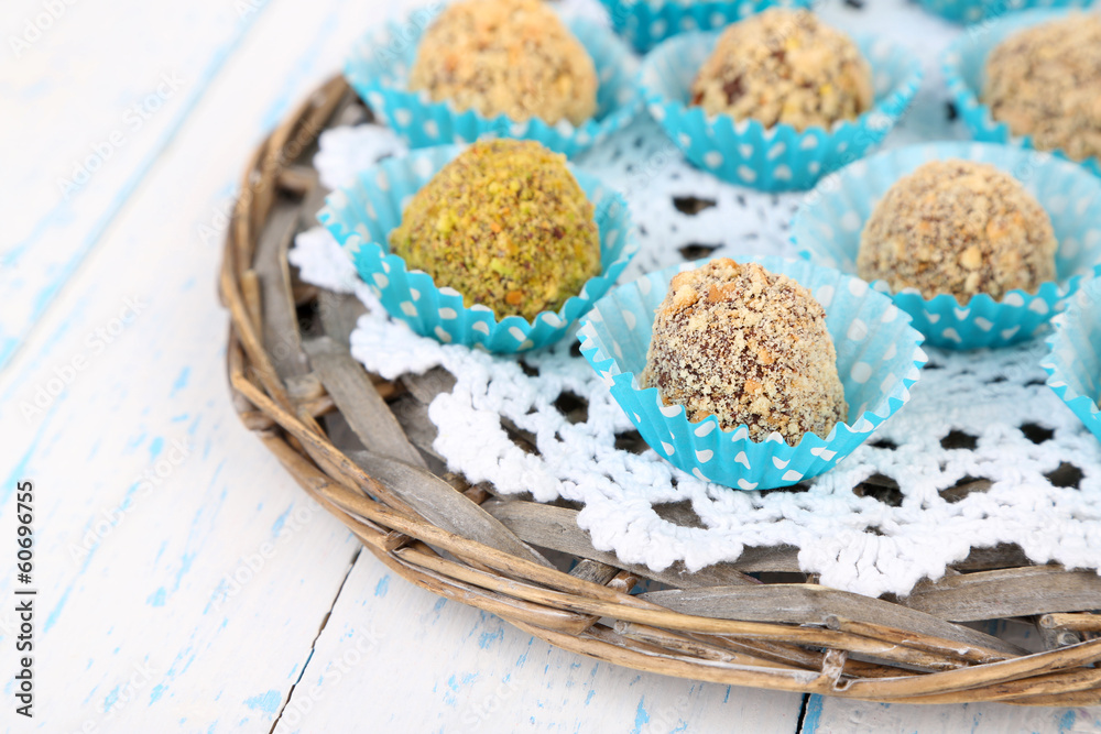 Set of chocolate candies, on wicker mat, on wooden background Set of chocolate candies, on wicker mat, on wooden background