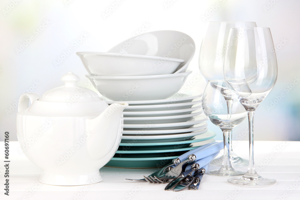 Clean dishes on table on bright background Clean dishes on table on bright background