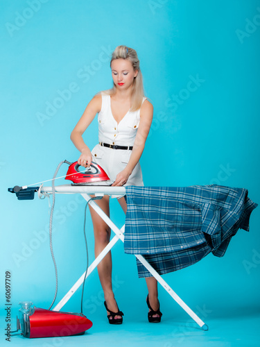 Obraz na płótnie Sexy girl ironing male shirt, woman housewife in domestic role.