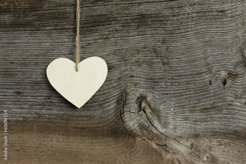 White Love Valentine's heart hanging on wooden texture backgroun