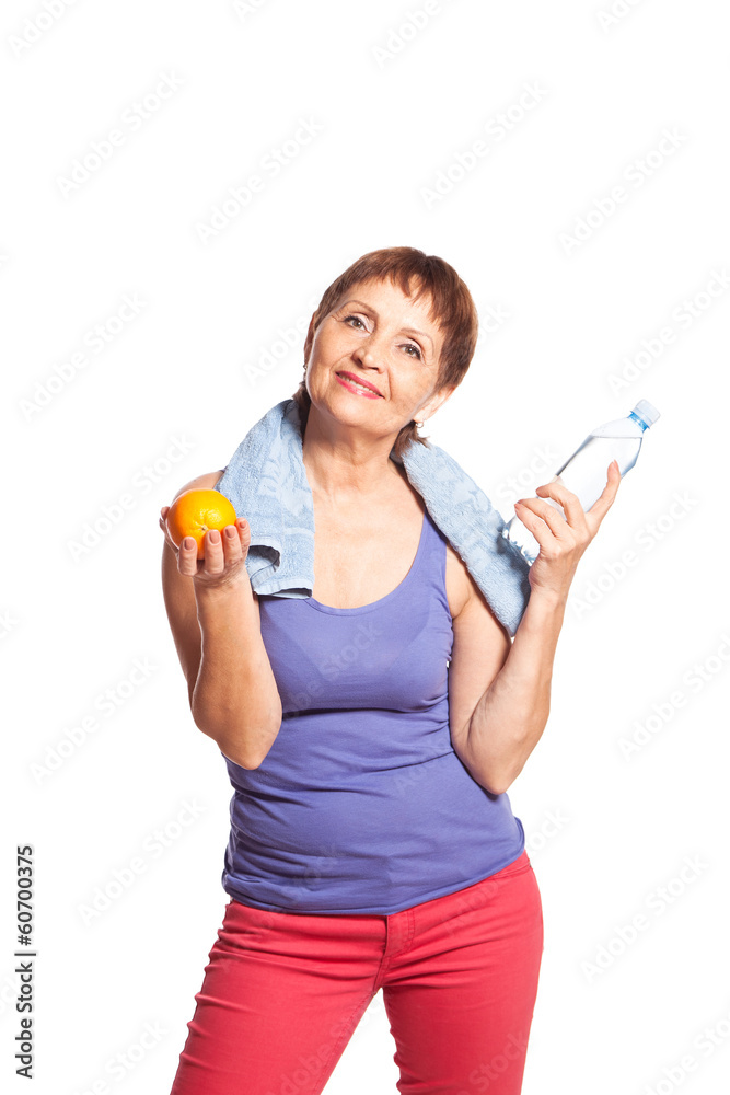 attractive woman 50 years with an orange and a bottle of water attractive woman 50 years with an orange and a bottle of water