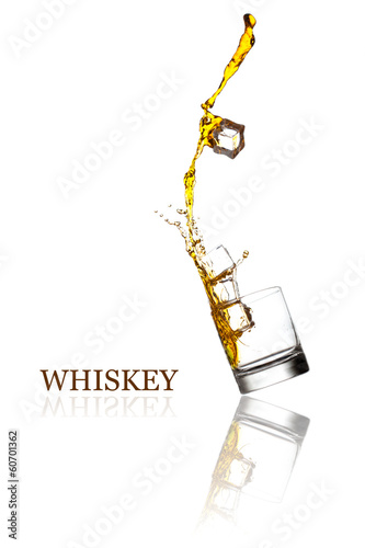 Glass with splashing whisky drink. Isolated on a white backgroun
