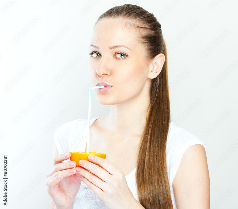 Attractive smiling young woman drinking orange juice straight fr Attractive smiling young woman drinking orange juice straight fr