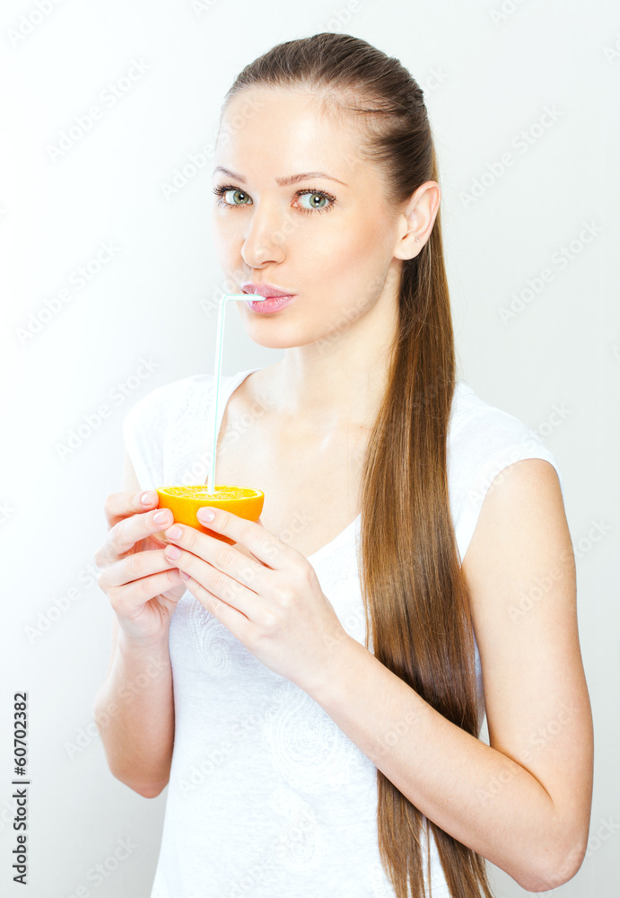 Attractive smiling young woman drinking orange juice straight fr Attractive smiling young woman drinking orange juice straight fr