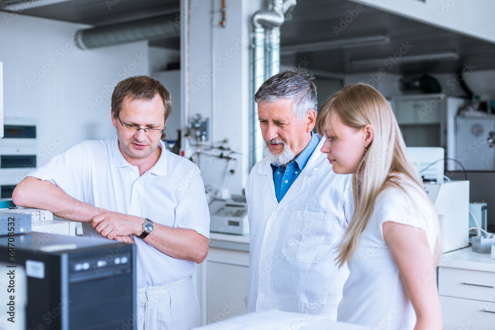Team of researchers carrying out experiments in a lab Team of researchers carrying out experiments in a lab