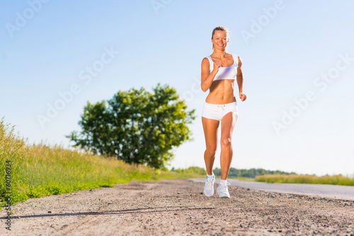 young athletic woman running on the road