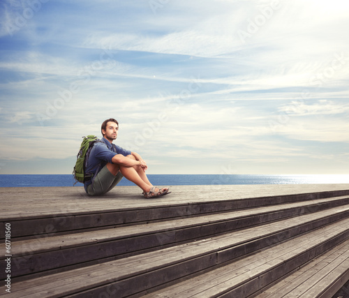 Young man sitting on a pier © SFIO CRACHO