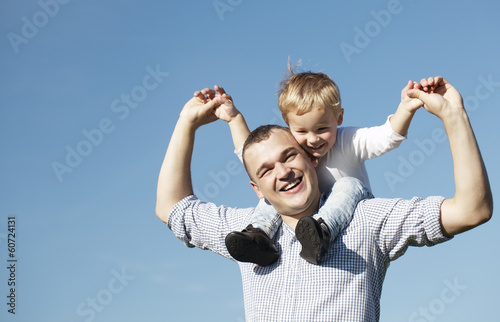 Dad giving his young son a piggy back ride