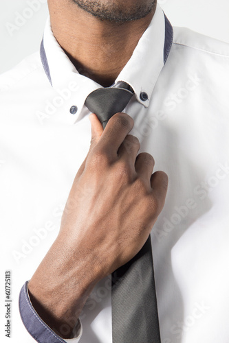 closeup of hand adjusting tie