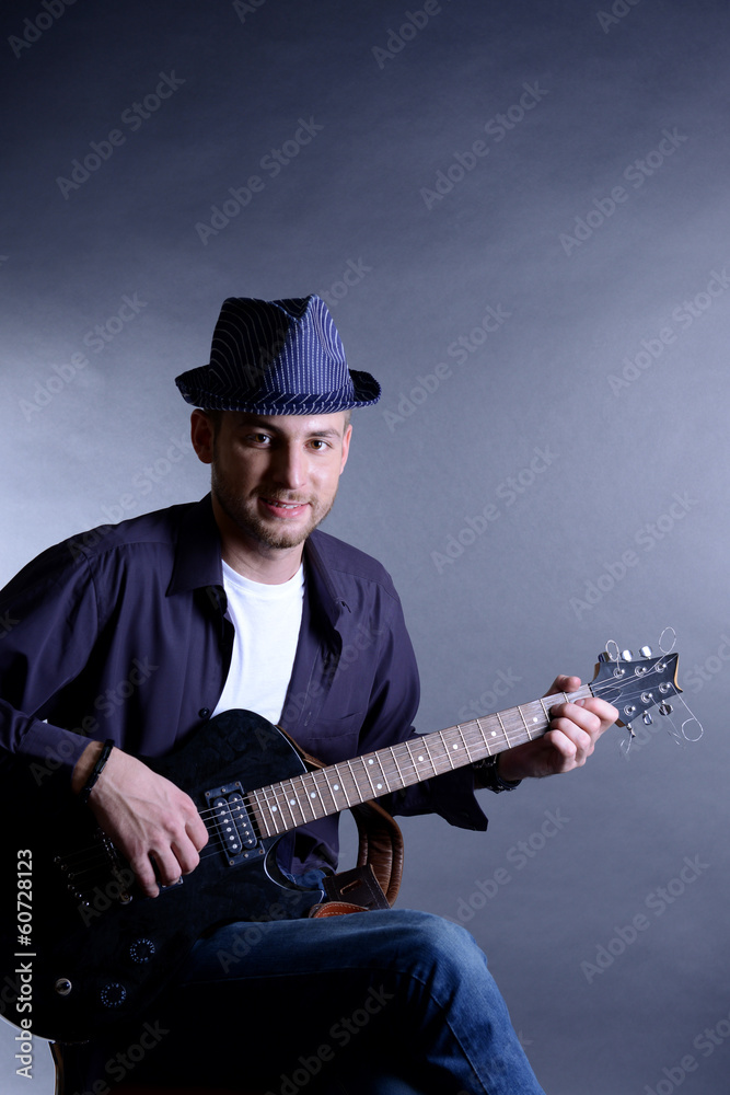 Obraz premium Young musician playing acoustic guitar and singing,