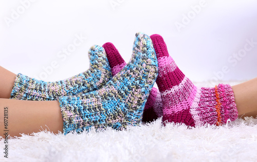 Legs in colorful socks on white carpet background