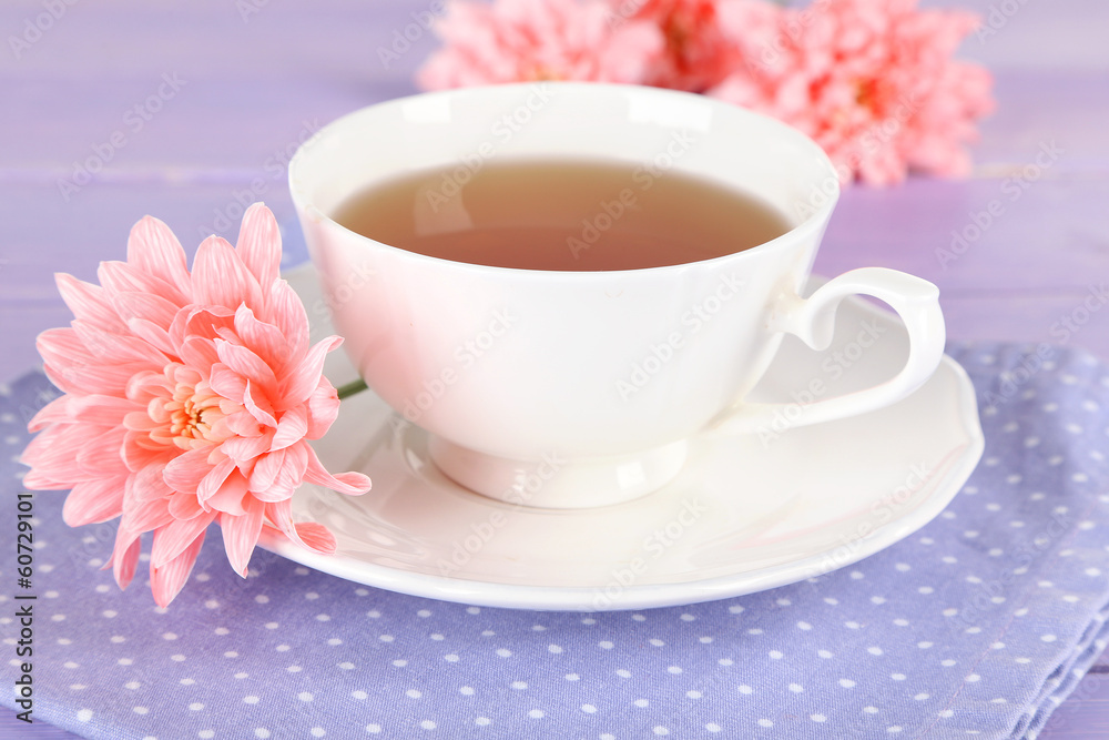 Fototapeta premium Pink chrysanthemums and cup of tea on wooden table
