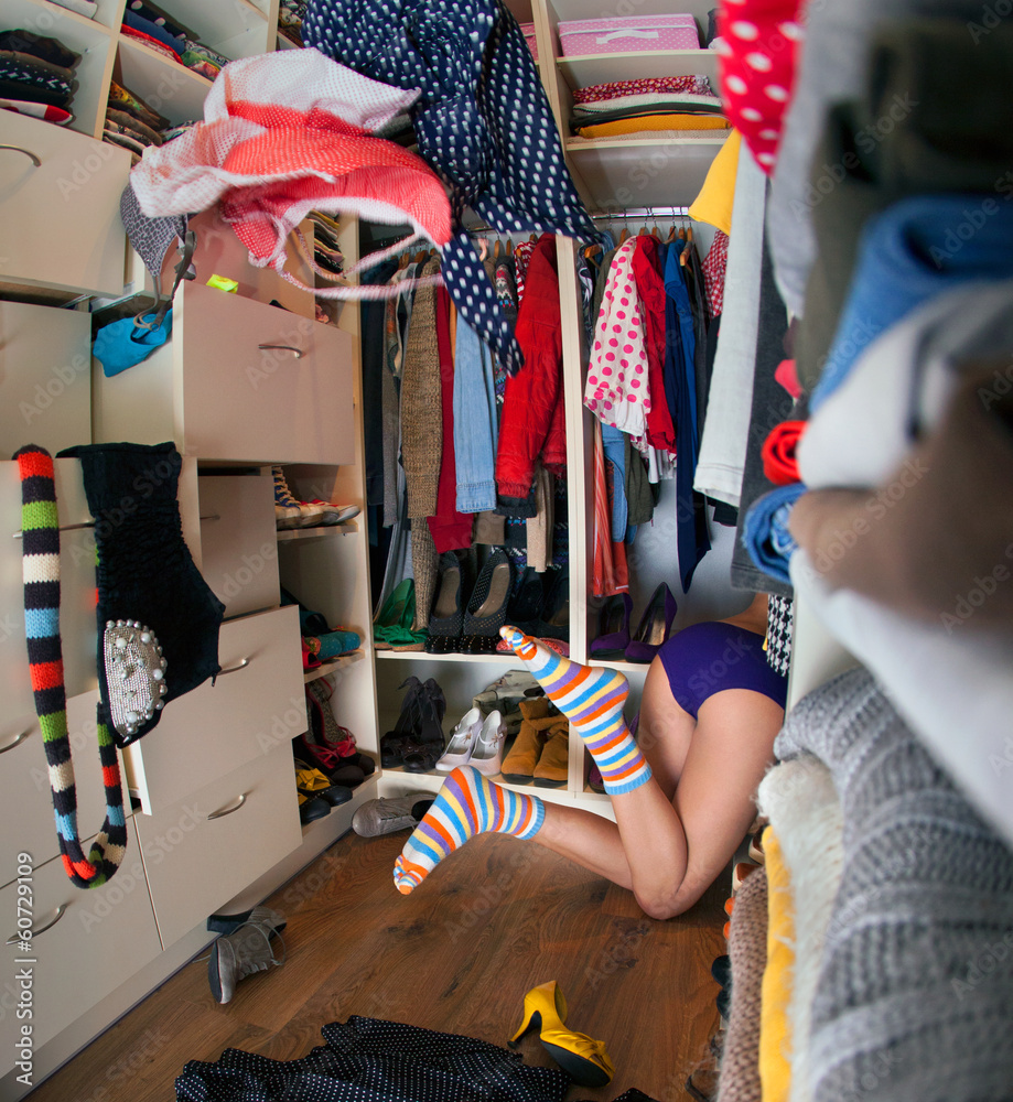 young woman searching for clothing in walk in closet