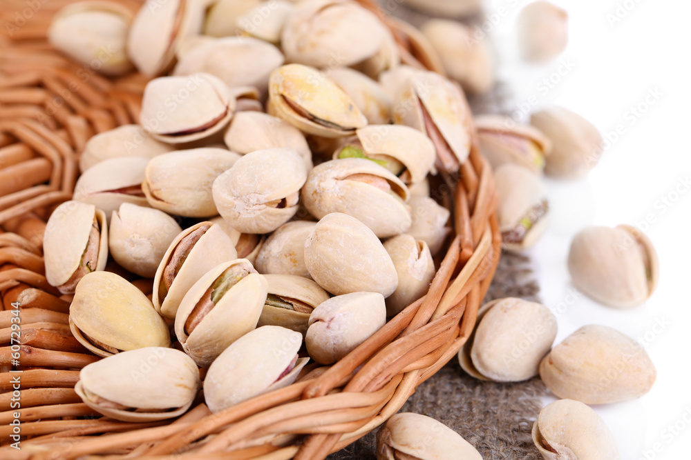 Pistachio nuts on wicker stand with sackcloth close up Pistachio nuts on wicker stand with sackcloth close up