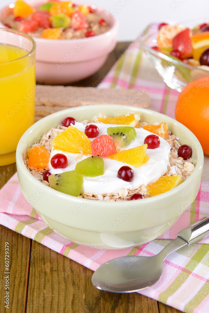 Delicious oatmeal with fruit in bowl on table close-up