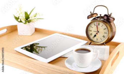 Tablet, newspaper, cup of coffee and alarm clock