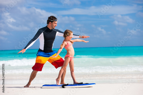 Father teaches daughter how to surf