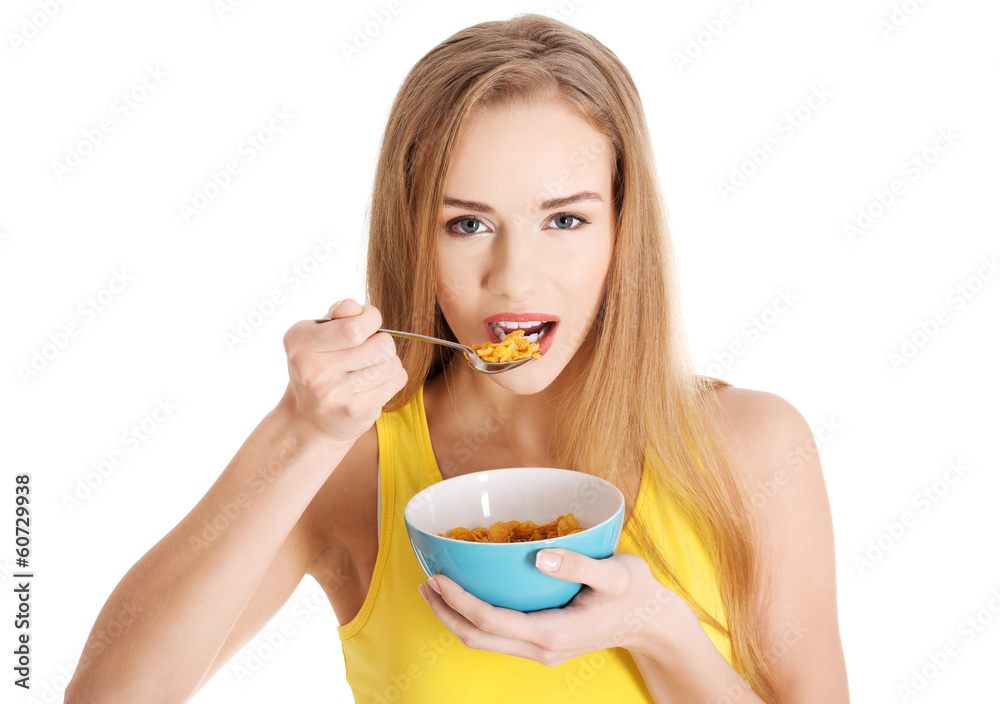 Beautiful caucasian slim woman eating corn flakes. Beautiful caucasian slim woman eating corn flakes.